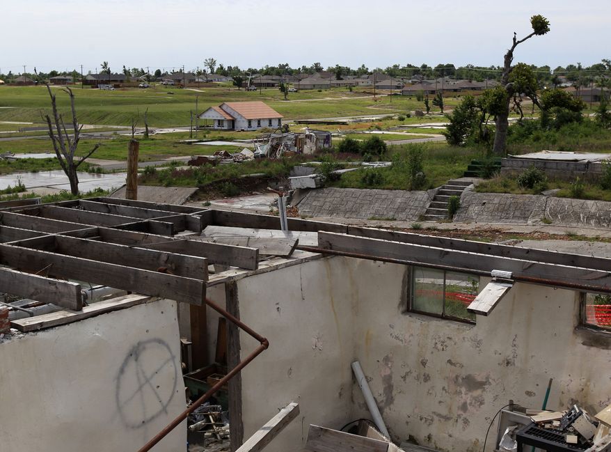 A new home rises among the ruins of other buildings on Tuesday, May 8, 2012, in a Joplin, Mo., neighborhood that was destroyed by an EF-5 tornado a year ago. (AP Photo/Charlie Riedel)