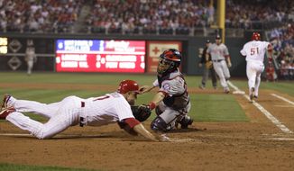 Washington Nationals catcher Jesus Flores, right, tags out Philadelphia Phillies&#39; Placido Polanco at home after Polanco tried to score on fielder&#39;s choice by Philadelphia Phillies&#39; Carlos Ruiz in the sixth inning of a baseball game, Monday, May 21, 2012, in Philadelphia. (AP Photo/Matt Slocum)