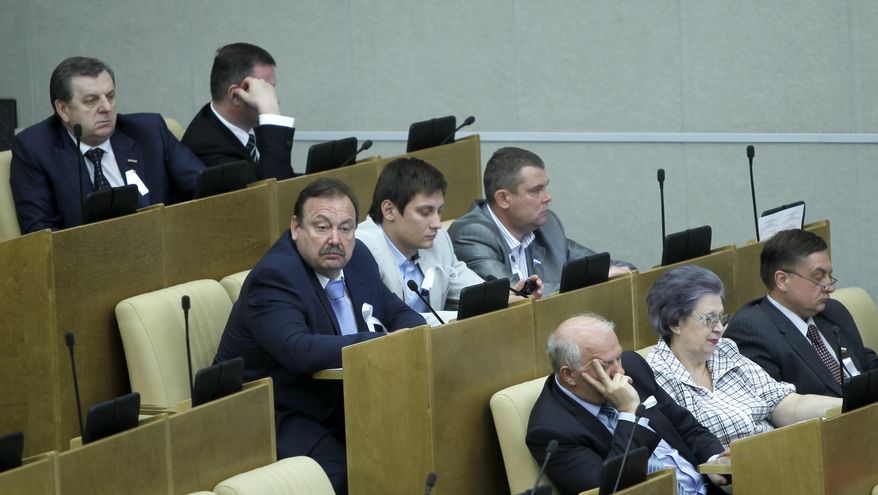 Members of the Just Russia opposition party wear white ribbons during a session of the Russian parliament in Moscow on Tuesday, May 22, 2012. Party members boycotted debates on a new bill introducing new tough sanctions against protesters. (AP Photo/Misha Japaridze)