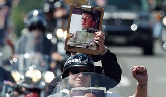 Bikers make their way across the Memorial bridge from Virgnia into Washington during the 18th annual Rolling Thunder ride on May 29, 2005. The message on the clipboard reads: “Love never loses its way home.” Seven years later and now marking its silver anniversary, Rolling Thunder is bigger than ever. (The Washington Times)