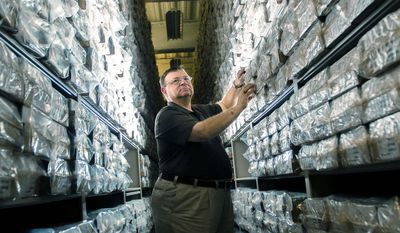 James Canik, deputy director of the Armed Forces DNA Identification Laboratory, searches among the vacuum-sealed DNA samples stored at the Armed Forces Repository of Specimen Samples at Dover Air Force Base. (Andrew S. Geraci/The Washington Times)