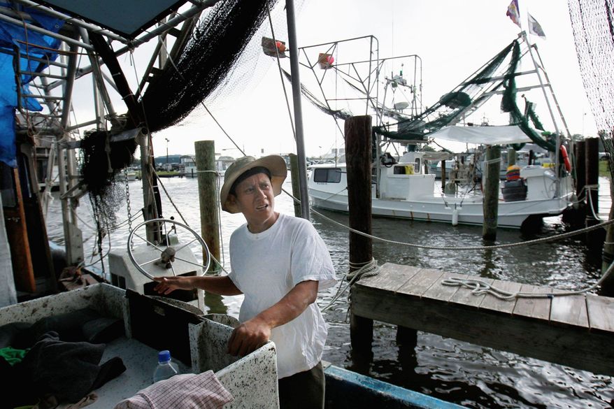 Tuna Pham, a shrimper, works on his idle boat in Lafitte, La., on May 16. The mood is gloomy on the hard-working shrimp and crab docks of this gritty fishing town, a traditional seafood basket for New Orleans. (Associated Press)