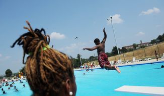 **FILE** Lifeguard Breanna Adams watches as children jump from the diving board at the Anacostia Pool and Recreation Center in Washington, D.C., on July 21, 2011. (Rod Lamkey Jr./The Washington Times)
