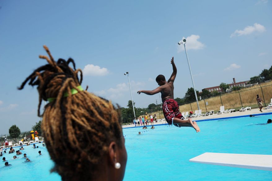 **FILE** Lifeguard Breanna Adams watches as children jump from the diving board at the Anacostia Pool and Recreation Center in Washington, D.C., on July 21, 2011. (Rod Lamkey Jr./The Washington Times)