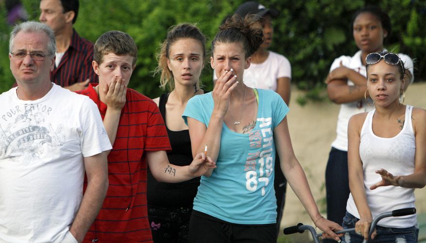 Neighbors in Northeast Philadelphia react as police remove the bodies of toddler twins on Thursday May 24, 2012, after they were found dead in their home. Police say the 18-month-old boy and girl appear to have died of suffocation and the mother is in custody. Police say their 41-year-old mother attempted to take her own life by slitting her wrists and they believe she gave some kind of prescription pills to her 4-year-old daughter. The 4-year-old girl is hospitalized. Information on her condition wasn't available. (AP Photo/Joseph Kaczmarek)