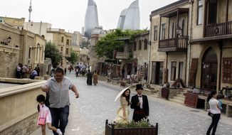 Pedestrians walk in downtown Baku, Azerbaijan, on May 22, 2012. The capital of this former Soviet republic has shed its dour, industrial image and evolved into a vibrant metropolis combining the old world charms of Istanbul with the architectural ostentations of Dubai. (Associated Press)