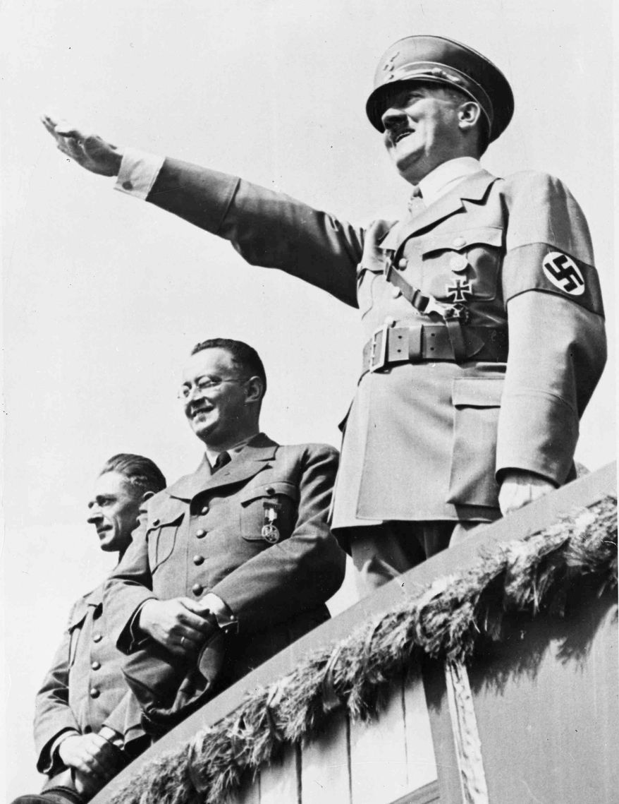 **FILE** German Chancellor Adolf Hitler (right) salutes a huge crowd July 31, 1938, at a sports meeting in Breslau, Germany. (Associated Press)
