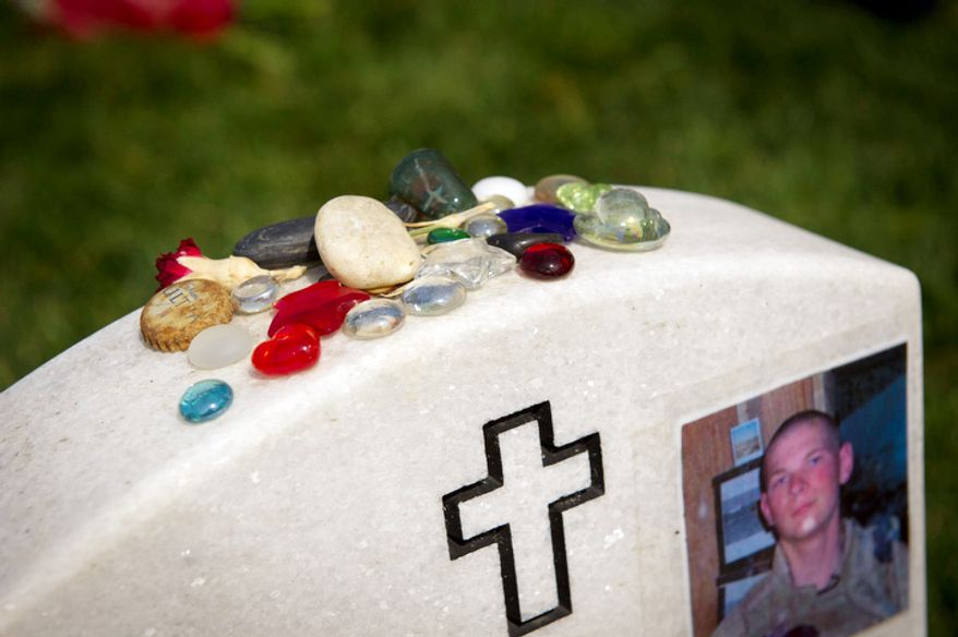 Rocks and colorful glass stones decorate the top of the headstone of U.S. Marine Corps. Lance Corporal Eric William Herzberg. (Rod Lamkey Jr/The Washington Times)