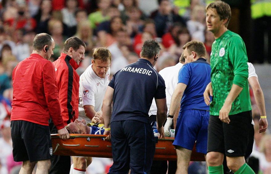 Gordon Ramsay of the Rest Of The World team, is carried from the pitch on a stretcher after a tackle by England's Teddy Sheringham, top centre left, during the Soccer Aid charity soccer match in aid of UNICEF at Old Trafford Stadium, Manchester, England, Sunday, May 27, 2012. (AP Photo/Jon Super)