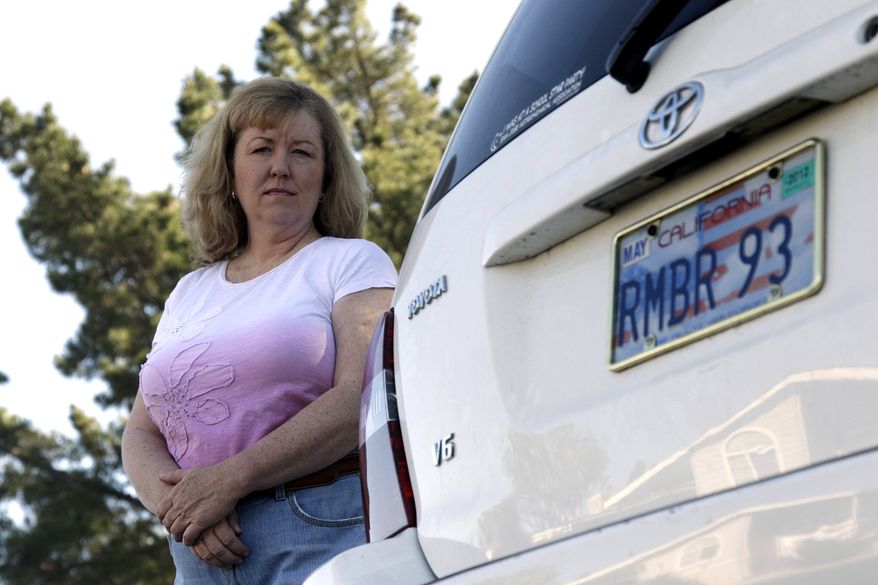 Candice Hoglan poses April 21, 2012, for a portrait with her vehicle with a license plate commemorating the events of Sept. 11, 2001, in Sunnyvale, Calif. Hoglan's nephew Mark Bingham was one of the passengers of United Airlines Flight 93, which was hijacked by terrorists on Sept. 11. (Associated Press)