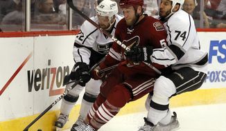 Los Angeles Kings Trevor Lewis (22) and Dwight King (74) pressure Phoenix Coyotes defenseman Derek Morris on the forecheck in the Western Conference final series. (AP Photo/Ross D. Franklin)