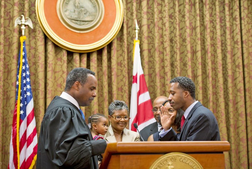 Judge Erik P. Christian of the D.C. Superior Court swears in Mr. McDuffie on Wednesday at the John A. Wilson Building. With him on the dais were his wife, daughter and parents. (Barbara L. Salisbury/The Washington Times)