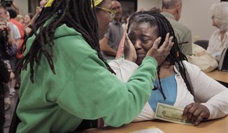 Janean Watkins (left) and Lakeesha Harris embrace after being the first in line to obtain a civil union license from the Cook County Office of Vital Records in Chicago on Wednesday, June 1, 2011. (AP Photo/M. Spencer Green)
