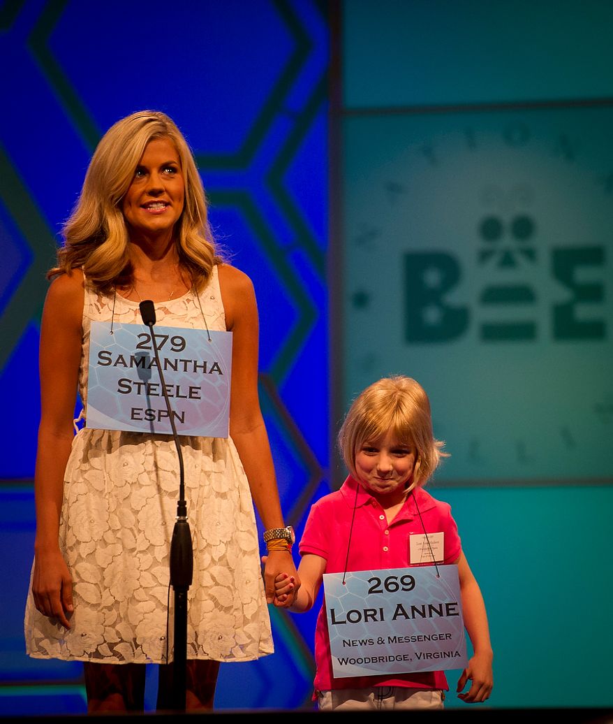 Six year-old Lori Anne C. Madison of Woodbridge, Va., is joined on stage as ESPN's Samantha Steele appears as a guest speller during the preliminary rounds of the 2012 Scripps National Spelling Bee at the Gaylord National Resort and Convention Center in National Harbor, Md., Wednesday, May 30, 2012. This year, 278 spellers from around the United States and all walks of life will compete for the title of 2012 Scripps National Spelling Bee champion. (Rod Lamkey Jr/The Washington Times)
