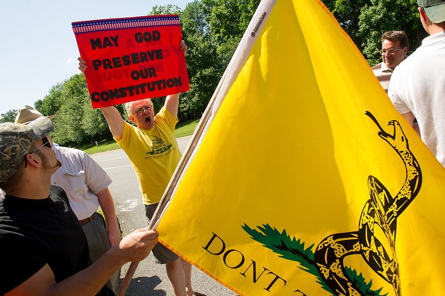 Protesters Frank Mineo, of Queensbury, N.Y., left, and Herb Schraw, of Toledo, Ohio, center, joins other protesters to demonstrate at the entrance to the Marriott Westfields where the annual Bilderberg Conference is being held, Chantilly, Va., Thursday, May 31, 2012. The Bilderberg Conference is an annual meeting of highly influential people in private industry and public office from North America and Western Europe. (Andrew Harnik/The Washington Times)