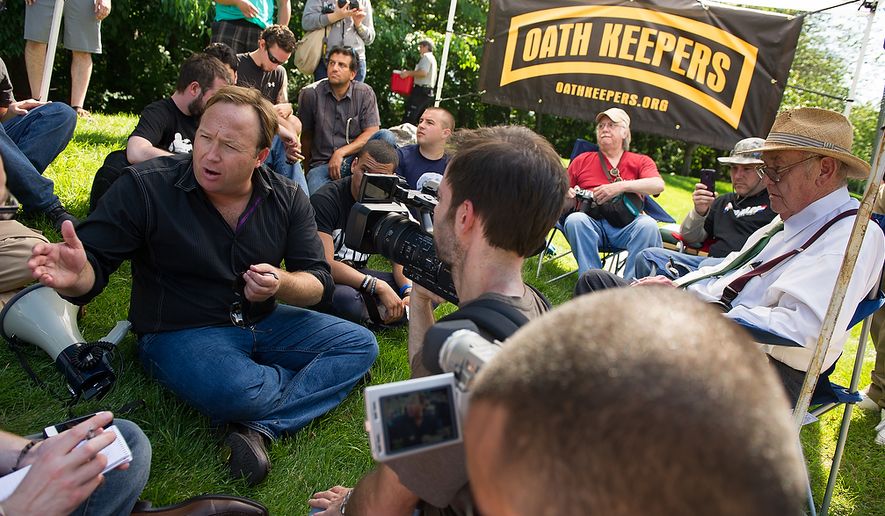 Alex Jones, a radio personality and conspiracy theorist, left, and Jim Tucker, an auther and journalist who has been writing about the Bilderberg Conference since 1975, right, speaks with protesters and members of the media during a demonstration at the entrance to the Marriott Westfields where the annual Bilderberg Conference is being held, Chantilly, Va., Thursday, May 31, 2012. (Andrew Harnik/The Washington Times)