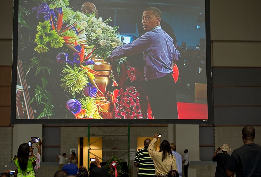 People take pictures with cell phones as Chuck Brown's grandson is seen on the large screen approaching the casket during the memorial service for D.C. Go Go icon Chuck Brown Thursday, May 31, 2012 at the Washington Convention Center in Washington, D.C. Thousands of people came out to say goodbye to the D.C. legend. (Barbara L. Salisbury/The Washington Times)