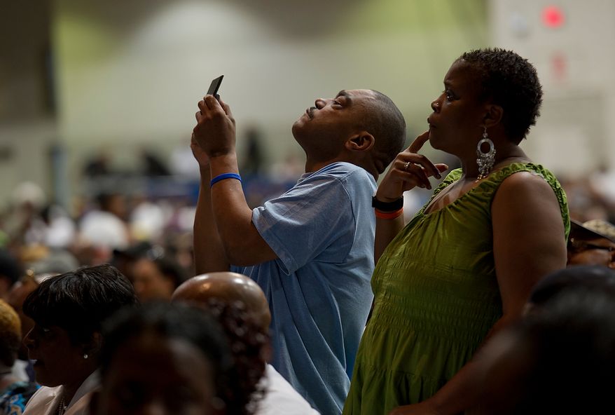 A man and woman in the crowd stand to get a better view of one of the tributes during the memorial service for Chuck Brown Thursday, May 31, 2012 at the Washington Convention Center in Washington, D.C. The event included several musical tributes to the man they call the Godfather of Go Go. (Barbara L. Salisbury/The Washington Times)