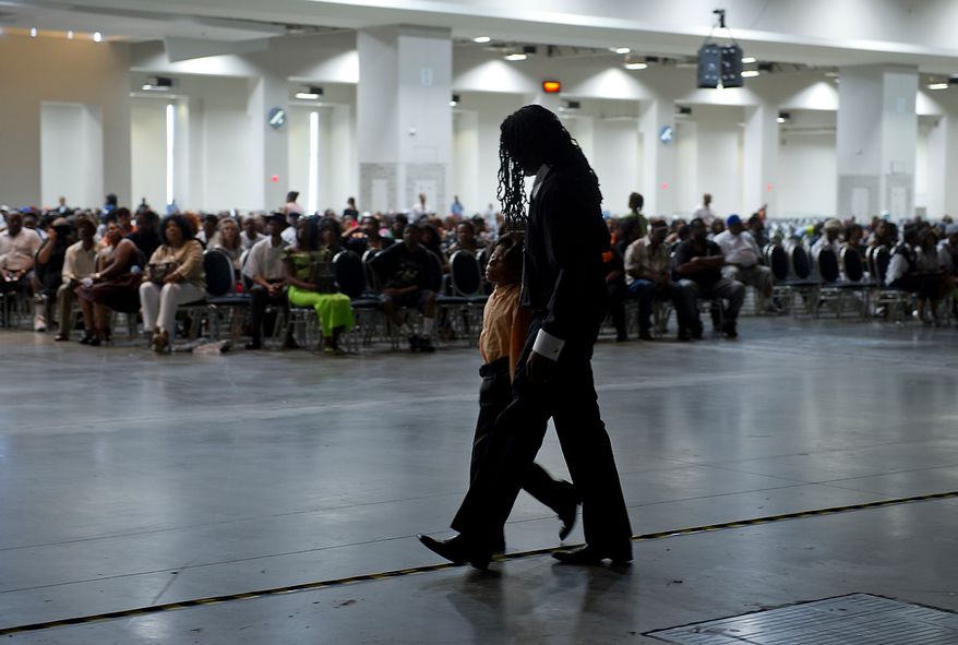 A man and his son walk back to their seats at the memorial service for D.C. Go-Go icon Chuck Brown Thursday, May 31, 2012 at the Washington Convention Center in Washington, D.C. Thousands of people came out to say goodbye to the D.C. legend. (Barbara L. Salisbury/The Washington Times)