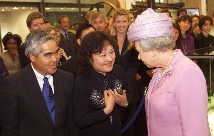 ** FILE ** In this Tuesday, June 27, 2000, file photo, Britain's Queen Elizabeth II, right, opens the new Wellcome Wing of London 's Science Museum with Associated Press photographer Nick Ut, left and Phan Thi Kim Phuc, center. Phuc was the main subject in Ut's iconic image of the aftermath of a June 8, 1972, napalm attack in Vietnam. The image is featured in the museum. (AP Photo/Ian Jones, Pool)