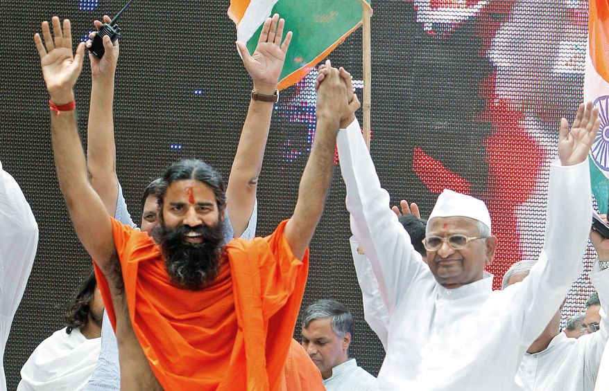 Baba Ramdev (left), an Indian yoga guru, and Anna Hazare, an Indian anti-corruption crusader, greet supporters during a fast in New Delhi on Sunday. The Indian anti-corruption campaigners held a daylong protest to press the government to act against widespread graft and bring back hundreds of billions of dollars stashed overseas. (Associated Press)