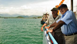 U.S. Secretary of Defense Leon E. Panetta (right) talks with Chief Mate Fred Cullen as he takes a boat out to the USNS Richard E. Byrd in Cam Ranh Bay, Vietnam, on Sunday, June 3, 2012. (AP Photo/Jim Watson, Pool)