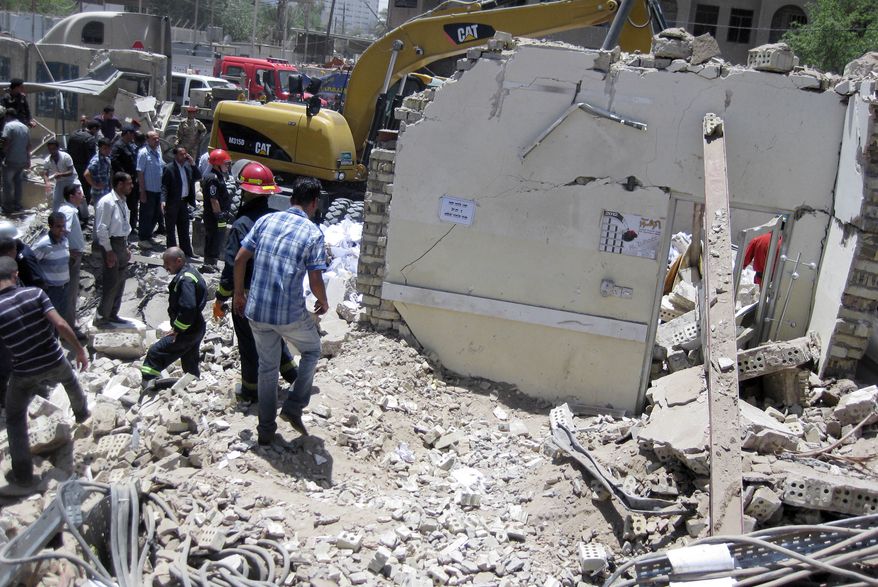 Firefighters and rescuers search for victims at the site of a bomb attack in the central Bab al-Muadham area of Baghdad on Monday, June 4, 2012. (AP Photo/Hadi Mizban)