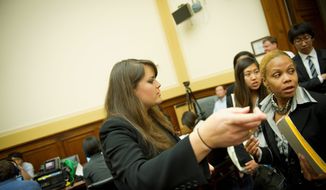 Jessica Santana, a staffer since February for Rep. Donald A. Manzullo, Illinois Republican, helps seat people arriving for a House subcommittee hearing Wednesday. Ms. Santana will need a new employer next year, as Mr. Manzullo will be leaving Congress in January. (Rod Lamkey Jr./The Washington Times)