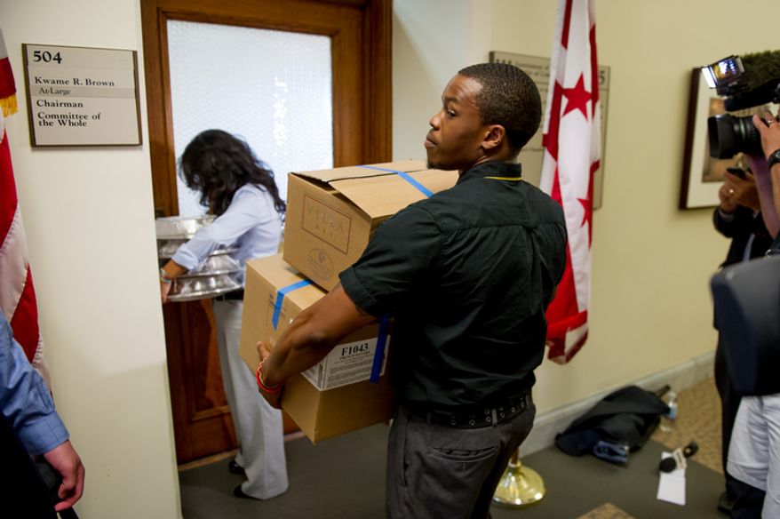 D.C. Council Chairman Kwame Brown's staff members carry food into the chairman's offices at the Wilson Building after being charged with one felony count of bank fraud, Washington, D.C., Wednesday, June 6, 2012. (Andrew Harnik/The Washington Times)
