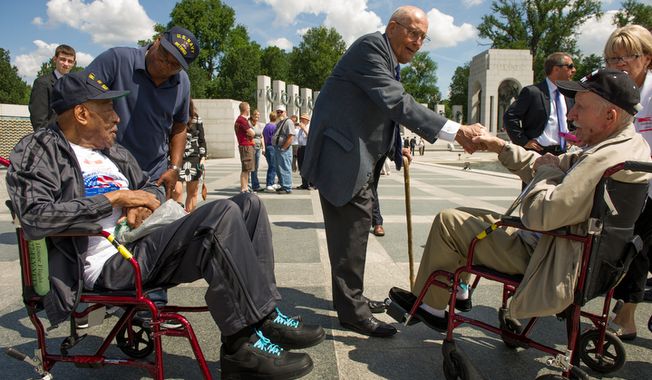 Rep. John D. Dingell (center), Michigan Democrat, speaks with retired Navy Seaman McKenley Morgan (left) of Flint, Mich.; his son Bruce Morgan (second from left) of Virginia Beach; and retired Army Sgt. Stanley Kaczor (right) of Woodhaven, Mich., at the World War II Memorial in Washington on Wednesday, June 6, 2012, the 68th anniversary of D-Day, as part of the Honor Flights program, which flies U.S. veterans to Washington to visit the memorials on the National Mall. Both the elder Mr. Morgan and Mr. Kaczor are World War II veterans, as is Mr. Dingell. (Andrew Harnik/The Washington Times)