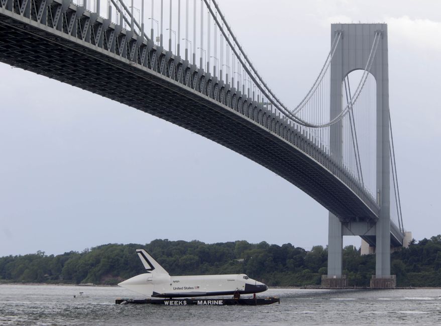 The space shuttle Enterprise is towed June 3, 2012, on a barge underneath the Verrazano-Narrows Bridge in New York. The prototype space shuttle that arrived in New York City by air earlier this spring is on the move again, this time by sea, to its final resting place at the Intrepid Sea, Air and Space Museum on the west side of Manhattan. (Associated Press)