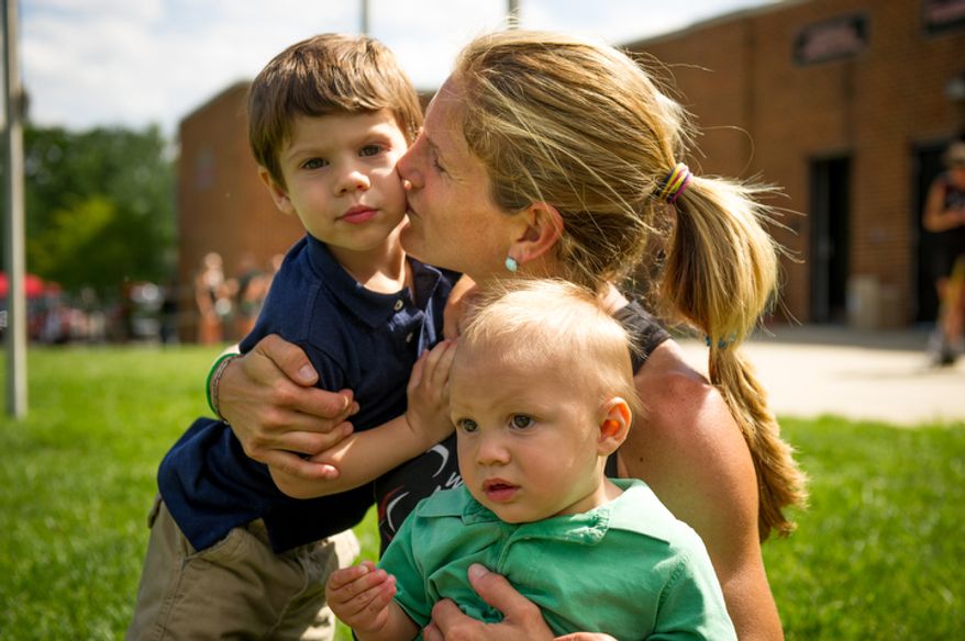 Keli Smith Puzo poses with her two children, Xavi Puzo, 2, right, and Ian Puzo, 9, left, between matches during the Women's National Championships of U.S.A. Field Hockey, College Park, Md., Monday, June 4, 2012. (Andrew Harnik/The Washington Times)