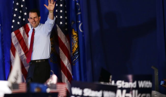 Republican Gov. Scott Walker of Wisconsin waves at his victory party on Tuesday, June 5, 2012, in Waukesha, Wis. Mr. Walker defeated Democratic challenger Tom Barrett in a special recall election. (AP Photo/Morry Gash)