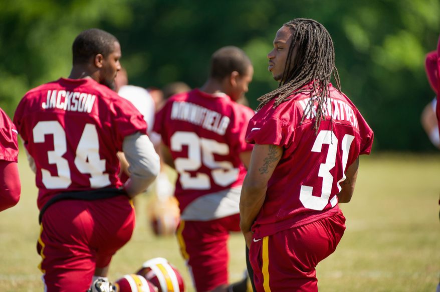 Redskins safeties Brandon Meriweather (right) and Tanard Jackson stretch during drills Thursday. Both were brought in during the offseason. (Associated Press)