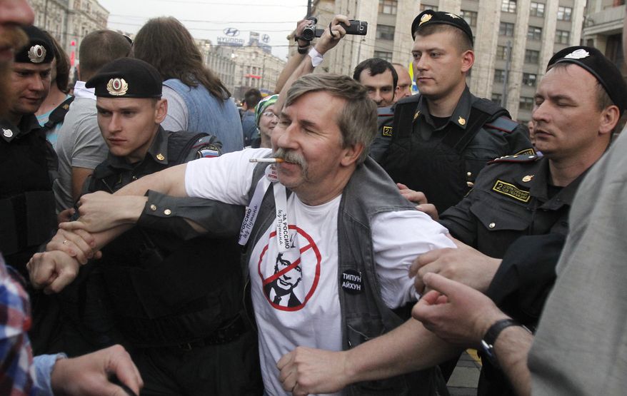 **FILE** Russian police detain a protester June 6, 2012, near the Kremlin in Moscow. Russian President Vladimir Putin has taken a harder line against the opposition since returning to the presidency a month ago. (Associated Press)