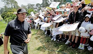** FILE ** In this file photo from June 2012, Phil Mickelson, signs for fans after a practice round. (Associated Press)