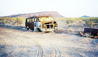 **FILE** A burned-out van sits in an Arizona wildlife refuge near Mexico, revealing an ominous dimension of cross-border human trafficking. (Associated Press)