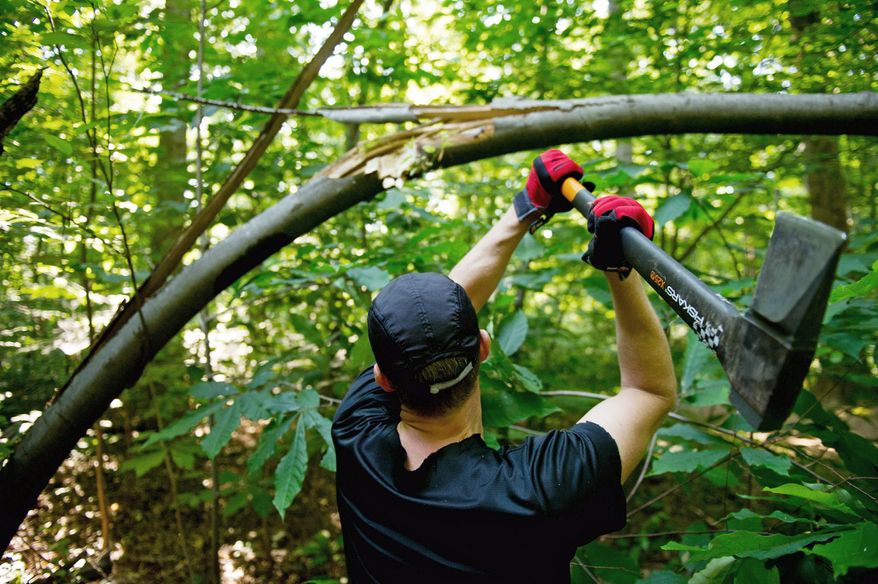 Mike Canino of Tyson's Corner, Va., cuts down and clears a fallen tree while training at the Scott's Run Nature Preserve for the Spartan Death Race, a tortuous combination of forced hikes, obstacle courses, sleep deprivation, and mental strain that is held annually in Vermont, McLean, Va., Sunday, June 10, 2012. (Andrew Harnik/The Washington Times)