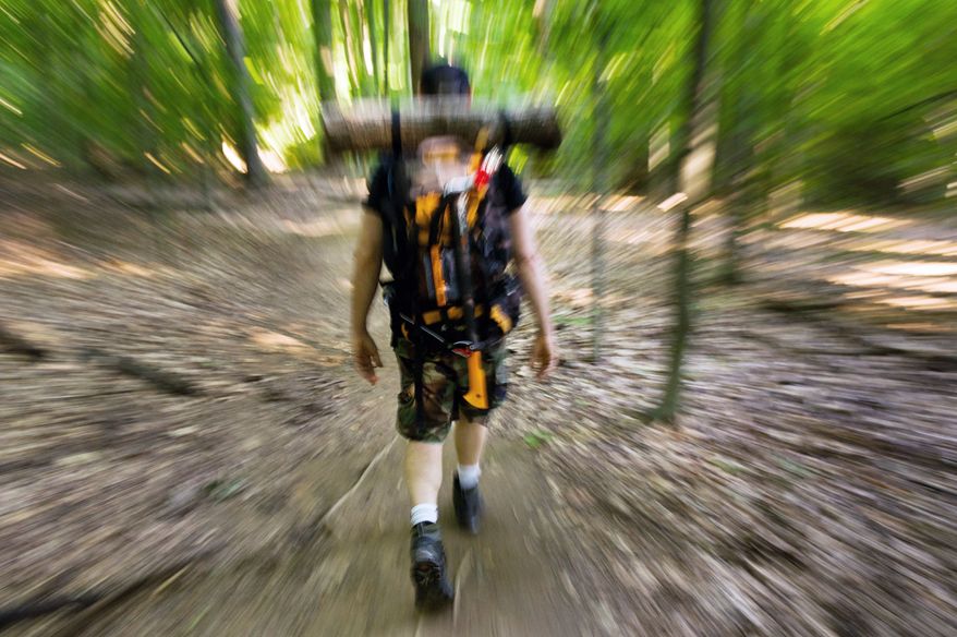 Mike Canino of Tyson's Corner, Va., straps a log he has named "Larry" to his backpack and hikes up and down steep terrains while training at the Scott's Run Nature Preserve for the Spartan Death Race, a tortuous combination of forced hikes, obstacle courses, sleep deprivation, and mental strain that is held annually in Vermont, McLean, Va., Sunday, June 10, 2012. (Andrew Harnik/The Washington Times)
