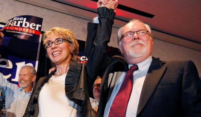 Democratic candidate Ron Barber celebrates his victory in a special election in Arizona Tuesday with Gabrielle Giffords, the congresswoman he succeeds, by his side. Mr. Barber easily topped Republican Jesse Kelly in a race in which both parties tested themes that will play out in the November election. (Associated Press)