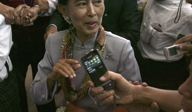 Myanmar opposition leader Aung San Suu Kyi talks to reporters as she arrives at Yangon International Airport on Wednesday, June 13, 2012, in Yangon, Myanmar, on her way to Europe for the first time in 24 years. (AP Photo)

