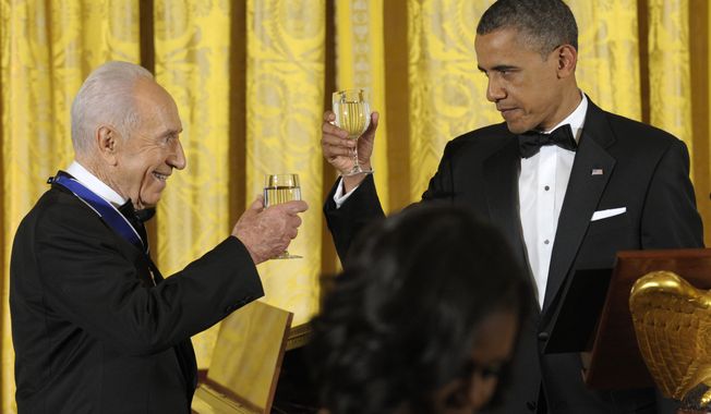 ** FILE ** President Obama and Israeli President Shimon Peres share a toast after Mr. Obama presented Mr. Peres with the Presidential Medal of Freedom at a dinner in the East Room of the White House in Washington on Wednesday, June 13, 2012. (AP Photo/Susan Walsh)