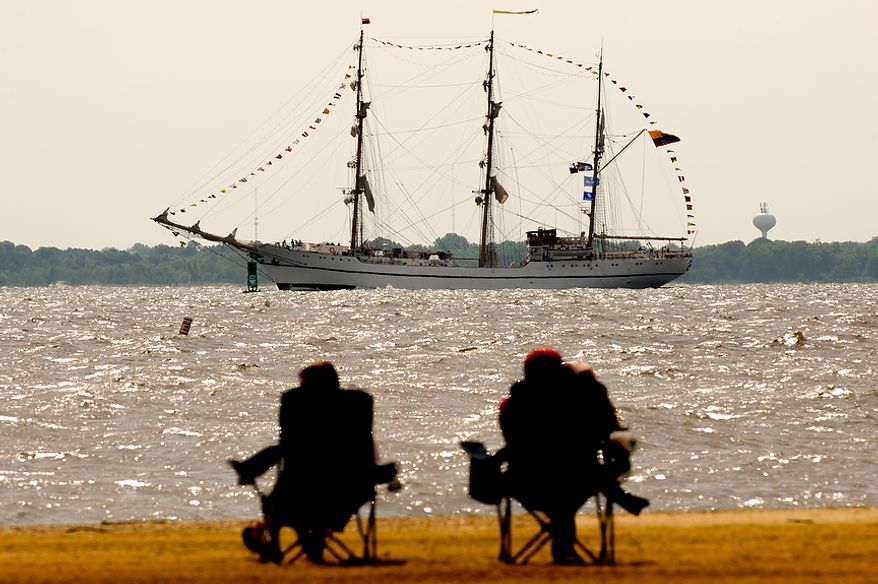 Beach-goers at Sandy Point State Park in Annapolis, Md., watch June 13, 2012, as tall ships pass under the Chesapeake Bay Bridge en route to the Inner Harbor in Baltimore for a bicentennial commemoration of the War of 1812. The week-long "Star-Spangled Sailabration" includes free tours of the ships, waterside festivities, an air show featuring the Blue Angels and the world premiere of "Overture for 2012," composed by Philip Glass. (Andrew Harnik/The Washington Times)