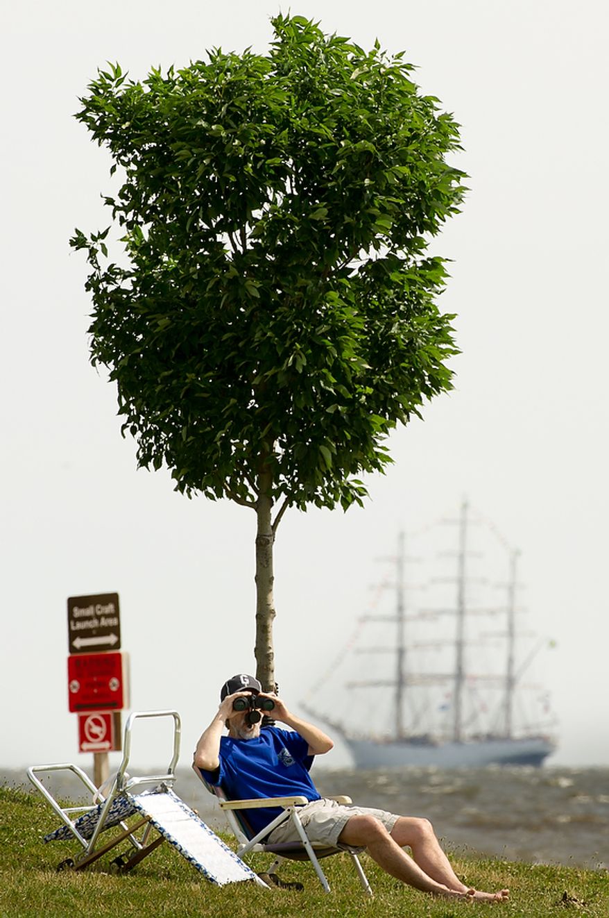 George Keniston, of Silver Spring, Md., watches June 13, 2012, through binoculars at Sandy Point State Park in Annapolis, Md., as tall ships pass under the Chesapeake Bay Bridge en route to the Inner Harbor in Baltimore for a bicentennial commemoration of the War of 1812. The week-long "Star-Spangled Sailabration" includes free tours of the ships, waterside festivities, an air show featuring the Blue Angels and the world premiere of "Overture for 2012," composed by Philip Glass. (Andrew Harnik/The Washington Times)