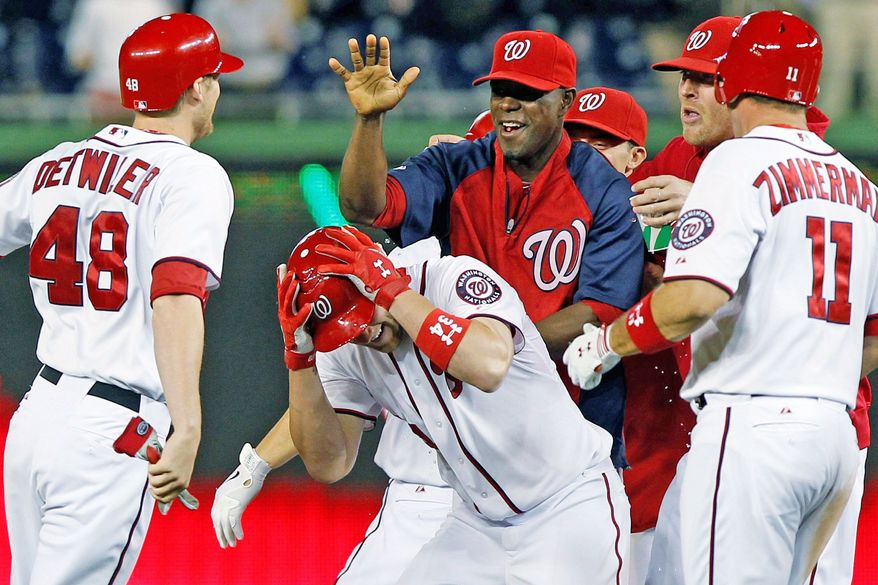 Washington Nationals&#39; Bryce Harper, center, celebrates with teammates after his scored the winning run during the 12th inning of a baseball game against the New York Mets, Tuesday, June 5, 2012, in Washington. The Nationals won 7-6. (AP Photo/Alex Brandon)