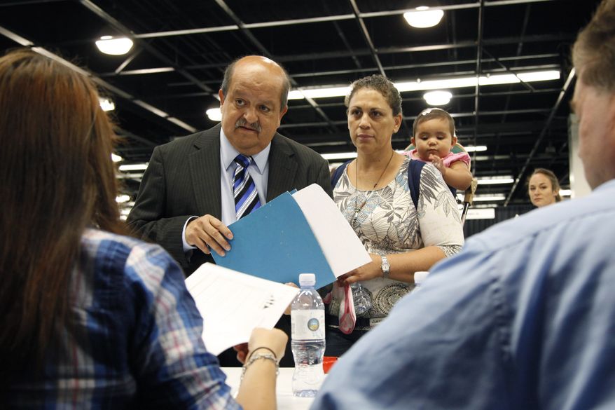 Jose Canales (left), accompanied by his wife, Magdel, and daughter Alexamarie, talks with a recruiter at a job fair in Anaheim, Calif., on Wednesday, June 13, 2012. (AP Photo/Jae C. Hong)