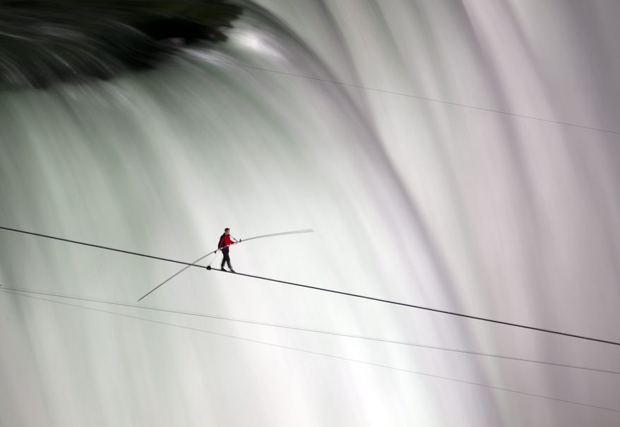 Nik Wallenda walks over Niagara Falls on a tightrope in Niagara Falls, Ontario, on Friday, June 15, 2012. Wallenda has finished his attempt to become the first person to walk on a tightrope 1,800 feet across the mist-fogged brink of roaring Niagara Falls. The seventh-generation member of the famed Flying Wallendas had long dreamed of pulling off the stunt, never before attempted. (AP Photo/The Canadian Press, Frank Gunn)