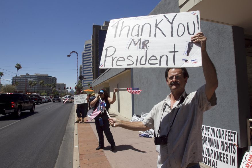 Nick Thomas, 53, of Phoenix holds a sign thanking President Obama at the Arizona Democratic Party in Phoenix on June 15, 2012, after the president announced the easing of enforcement of immigration laws, effective immediately. The new policy offers a chance for hundreds of thousands of younger illegal immigrants to stay in the U.S. and work. (Associated Press/The Arizona Republic)