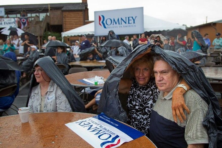 Supporters of Mitt Romney wait in the rain for the former Massachusetts governor's arrival for a campaign event Sunday in the Cleveland suburb of Brunswick, Ohio. (Associated Press)