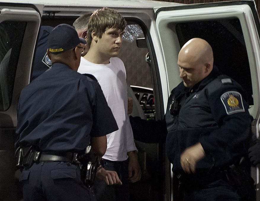Travis Baumgartner is taken out of a van by Canadian Border Services officers at the Aldergrove, British Columbia, border crossing on Saturday, June 16, 2012. (AP Photo/Jonathan Hayward, Canadian Press)